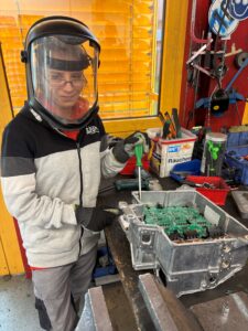 Ramona Lerch schraubt ein E-Auto-Steuergerät auf.