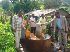 Wasserstelle wird in Betrieb genommen. An jedem der vier Wasserhähne steht eine Person und Sie demonstrieren die Funktion
