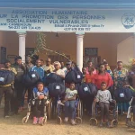 Knapp 30 Menschen mit und ohne Behinderung präsentieren die frisch produzierten Klima-Kocher vor der Zentrale von AHPPV